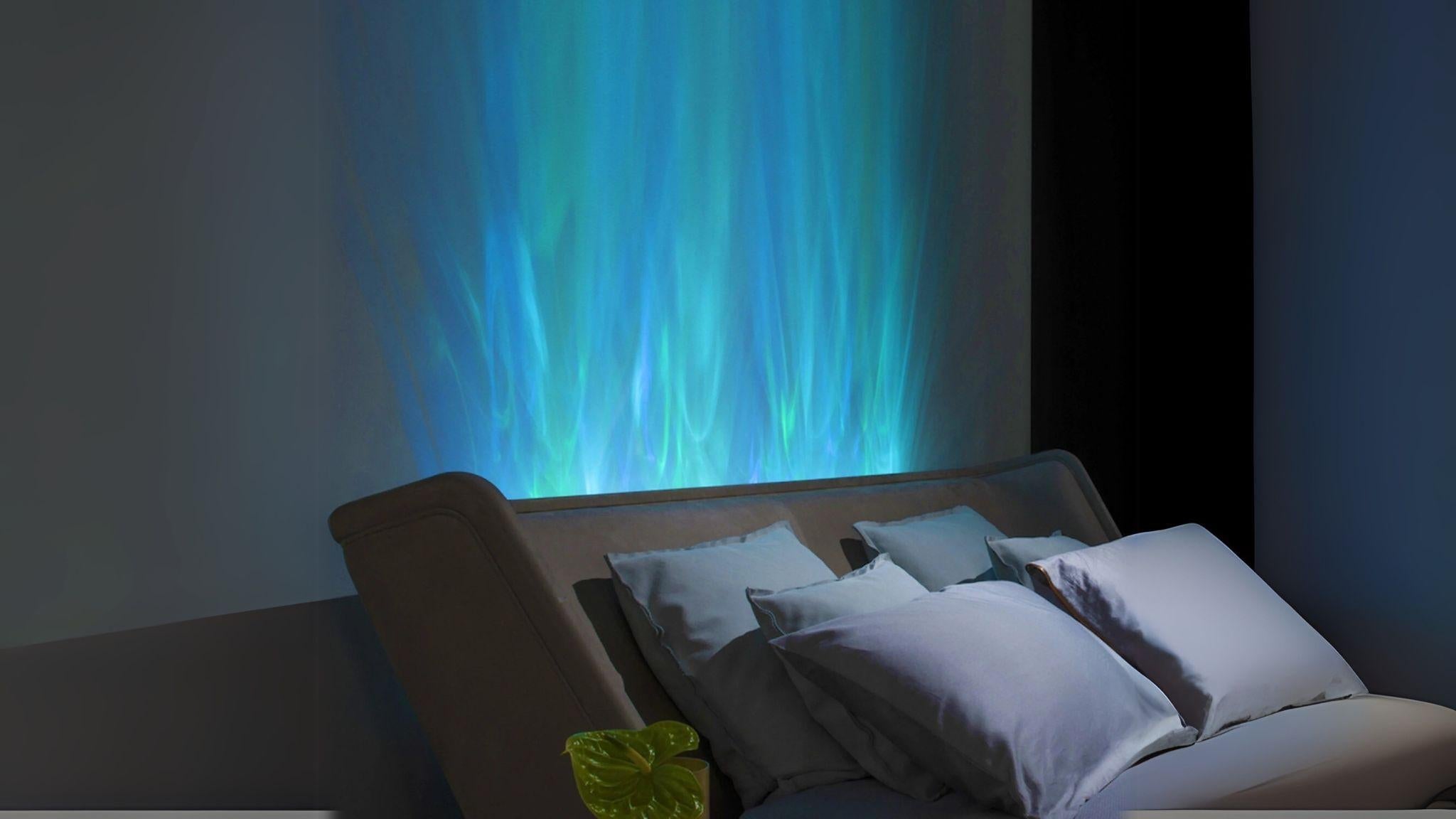 40" RGBW Ocean Wave Lights projecting vibrant blue ocean wave effects above a bedroom headboard for ambiance.