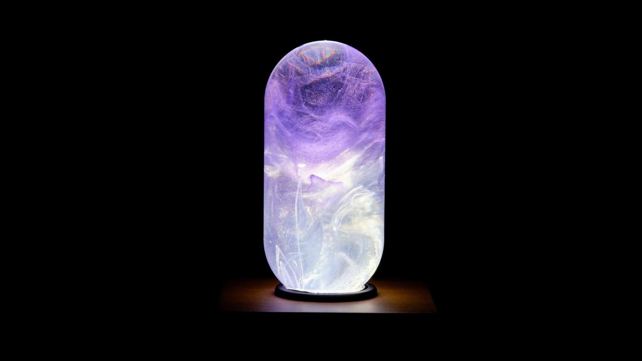 EP Light - Amethyst bulb glowing with unique handcrafted purple and white resin design on wooden base.