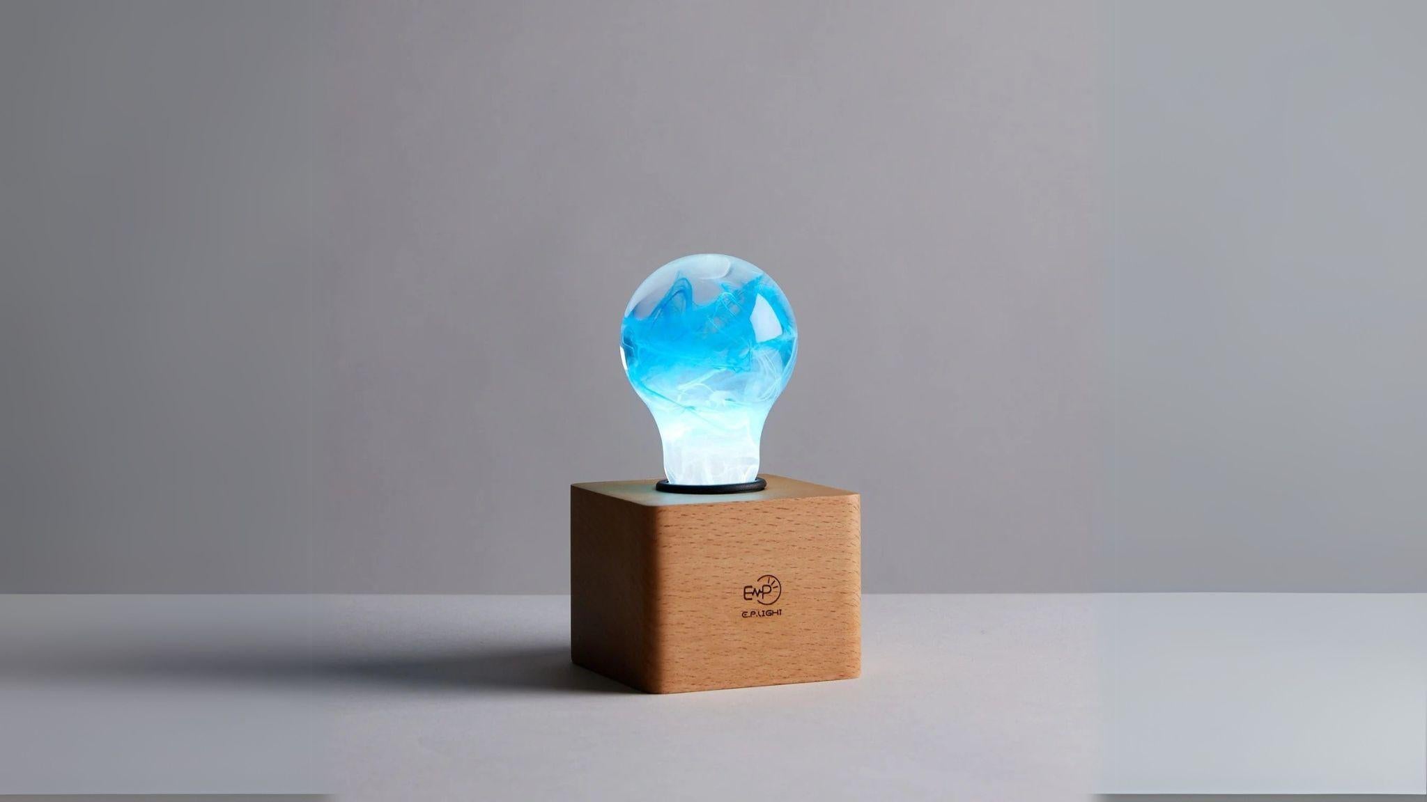 EP Light - Memory bulb glowing with unique blue swirl design on a vintage wooden base, handcrafted eco-resin light.