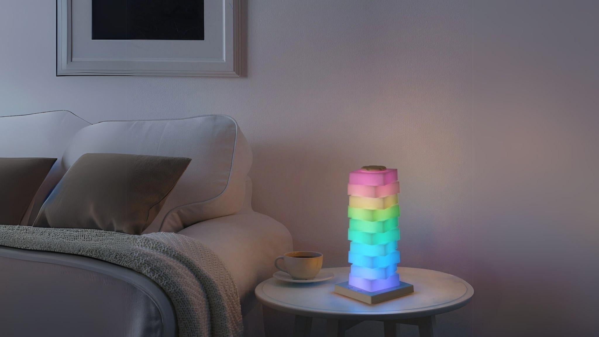 Modular Rotating Touch RGB Lamp glowing in vibrant colors on a side table, perfect for creative ambiance.