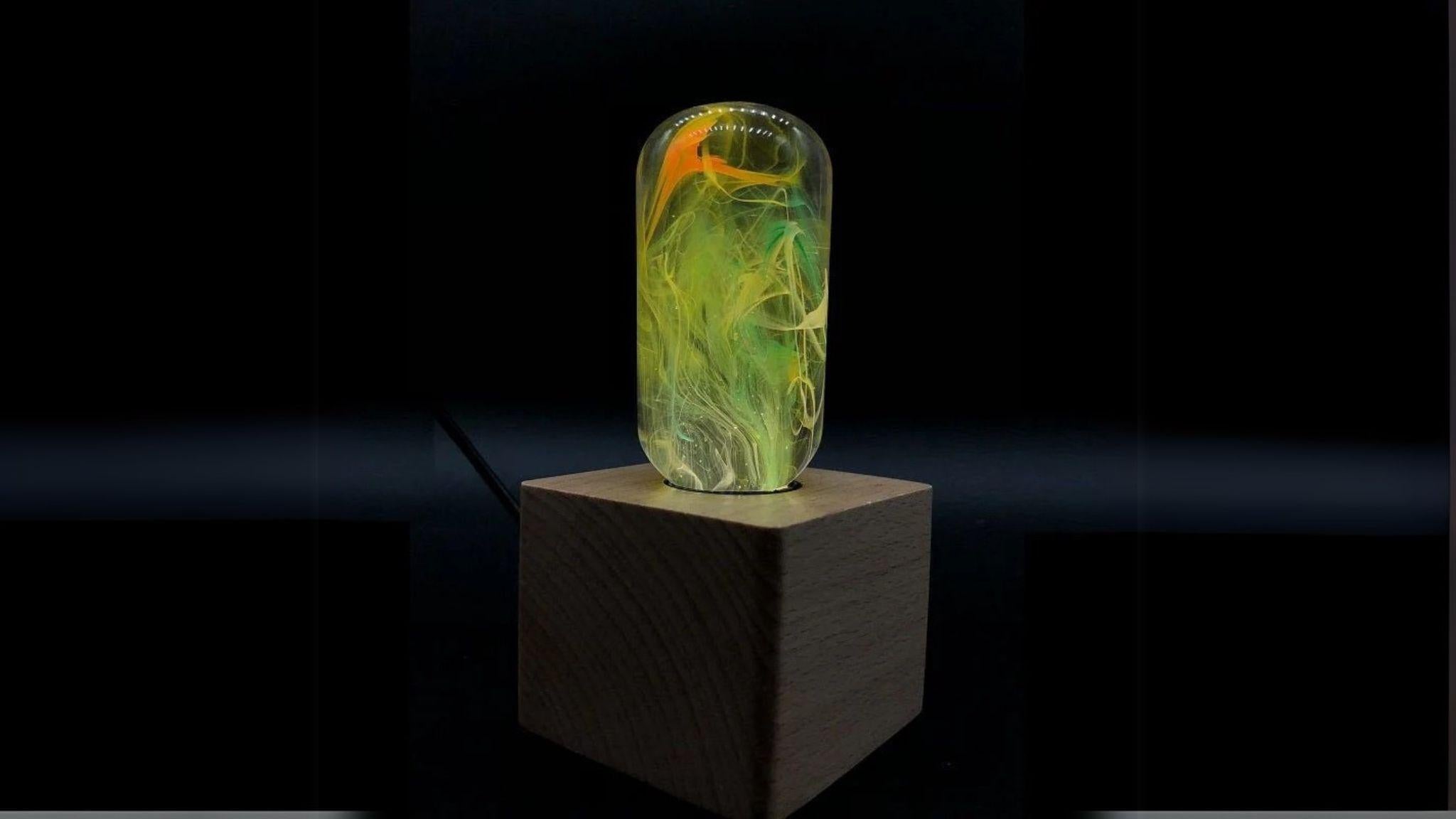 EP Light - Time handcrafted eco-resin bulb with unique artistic patterns illuminating a wooden base.