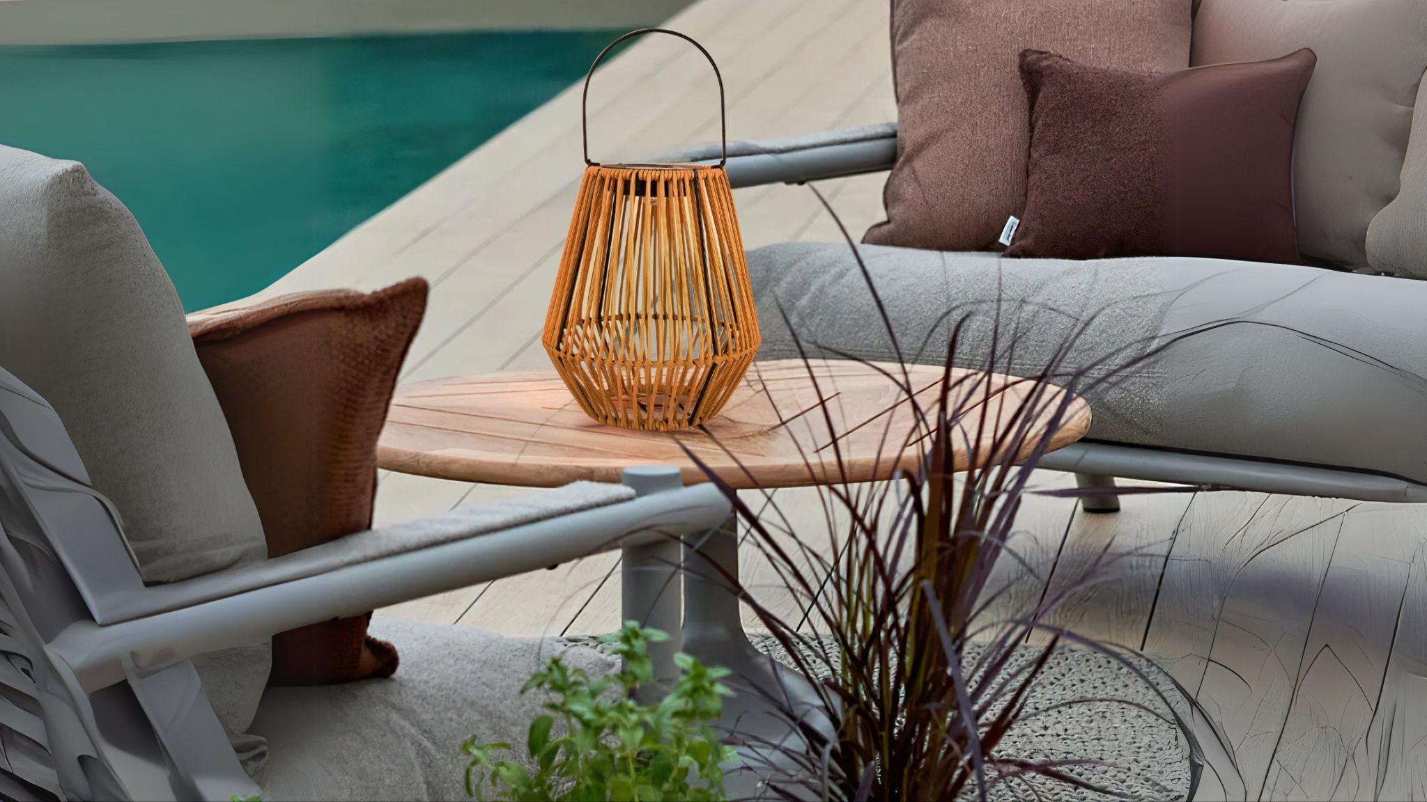 Solar Powered Outdoor Rattan Lantern on a wooden table enhancing cozy outdoor patio ambiance.