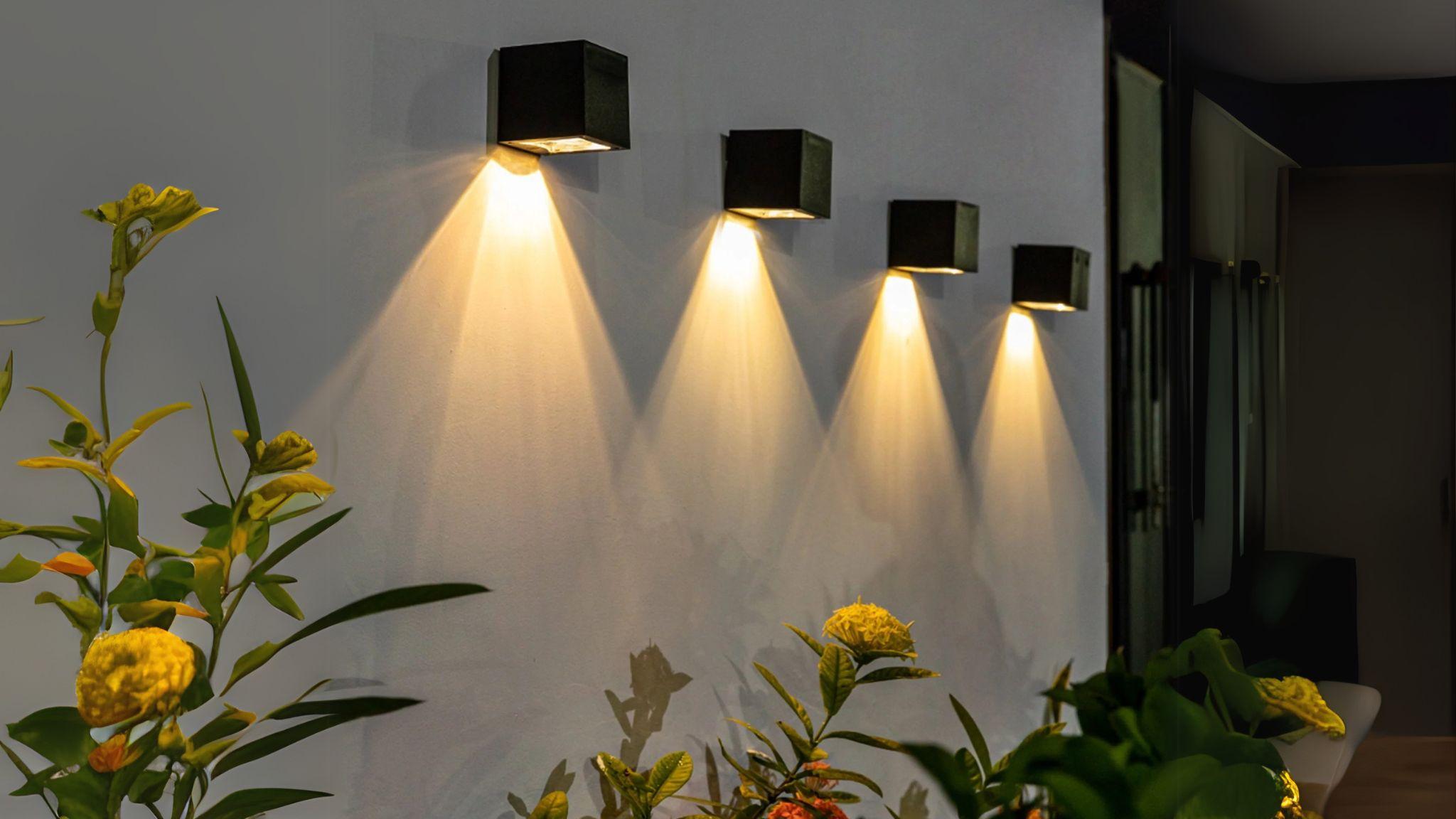 Solar Powered Outdoor Landscape Wall Lights illuminating a garden wall with warm, weatherproof, cordless brightness at night.