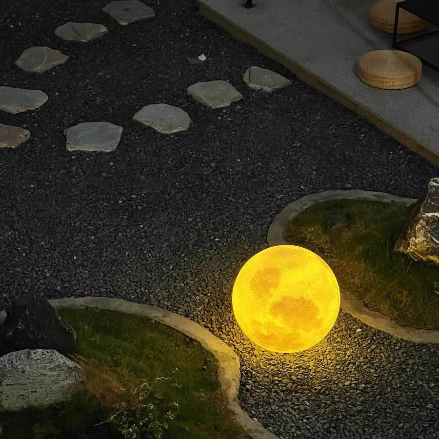 3D Moon Indoor & Outdoor Floor Lamp glowing warmly on garden path, perfect for stylish indoor and outdoor lighting.