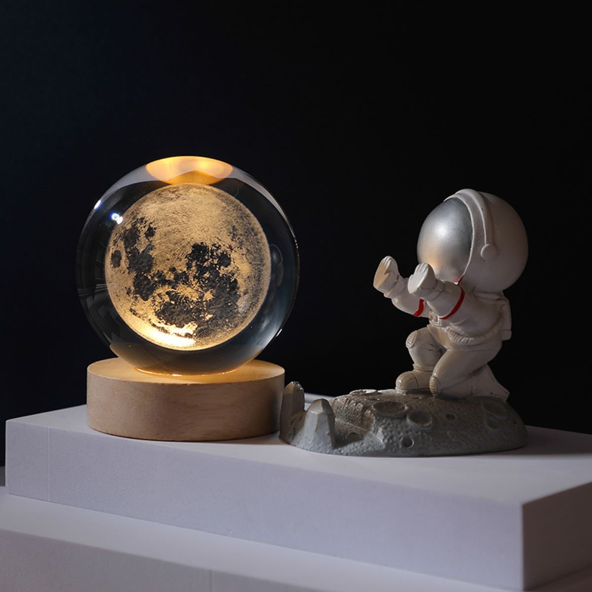 3D Solar System Crystal Ball Light displaying a glowing moon inside a crystal ball on a wooden base next to a small astronaut figure.