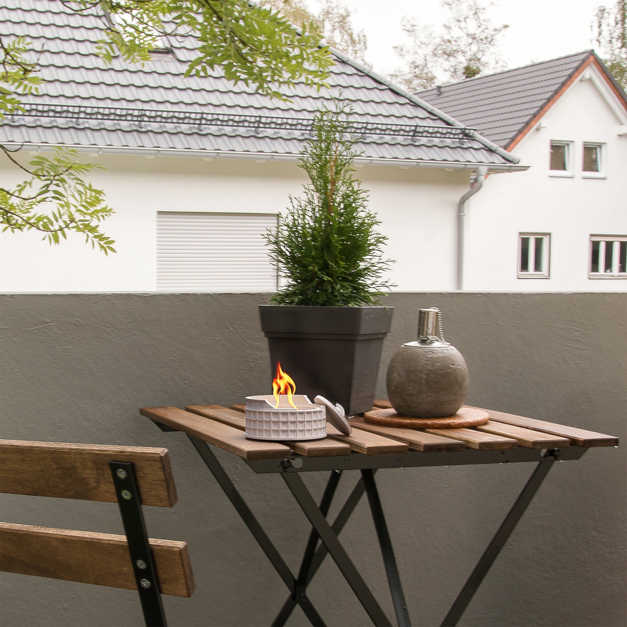 Colosseum Tabletop Fire Pit on patio table, providing smokeless warmth and cozy flame ambiance in a compact design.