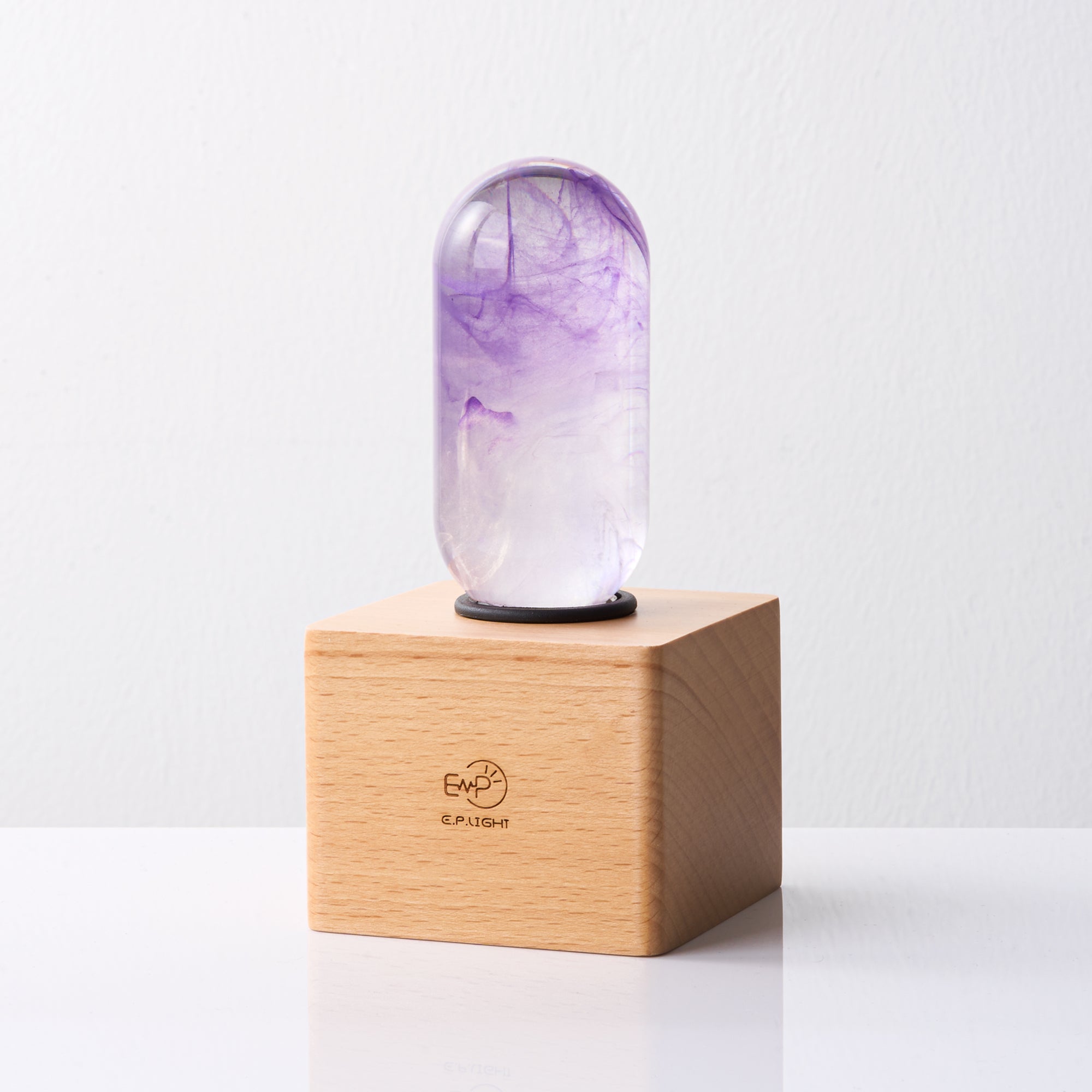 EP Light - Amethyst handcrafted eco-resin bulb with vibrant purple hues on a wooden base, combining elegance and energy efficiency.