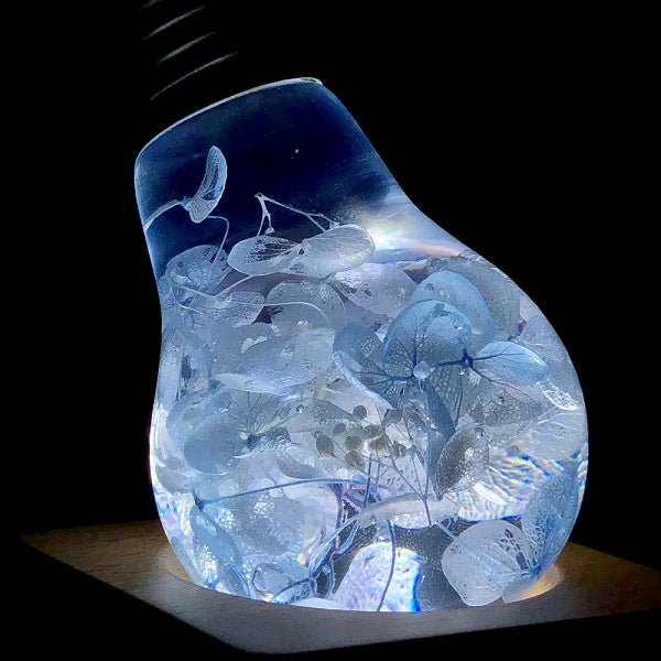 EP Light- Blue Hydrangea bulb glowing with unique blue floral resin design in an energy-saving LED light bulb.