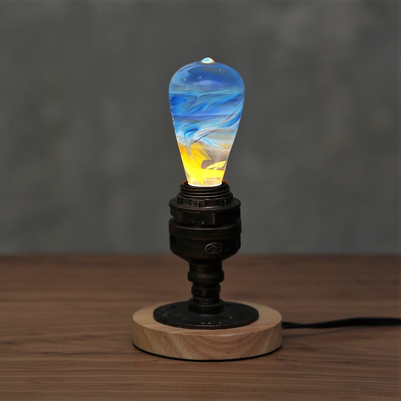 EP Light - Fire bulb glowing with unique amber, crimson, and gold flame effect in a modern wooden base lamp.