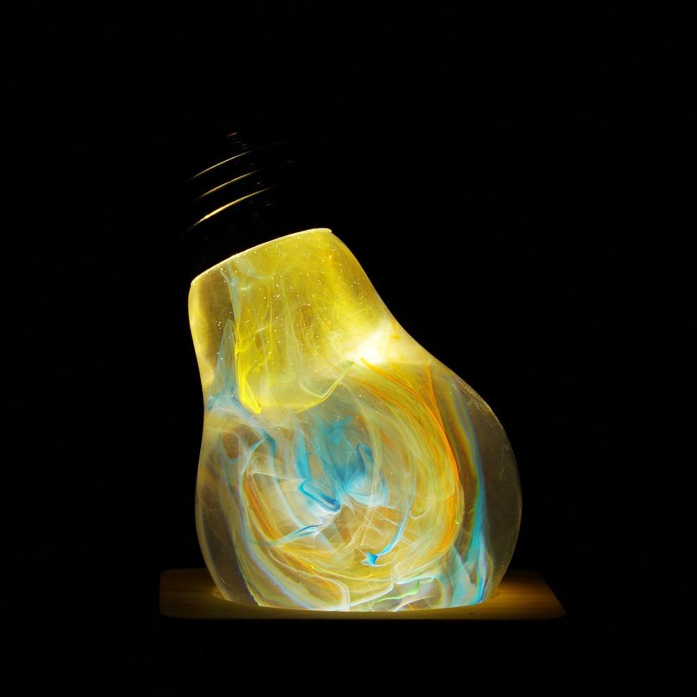 EP Light - Firework bulb glowing with vibrant yellow and blue handcrafted eco-resin design, creating a unique festive ambiance.