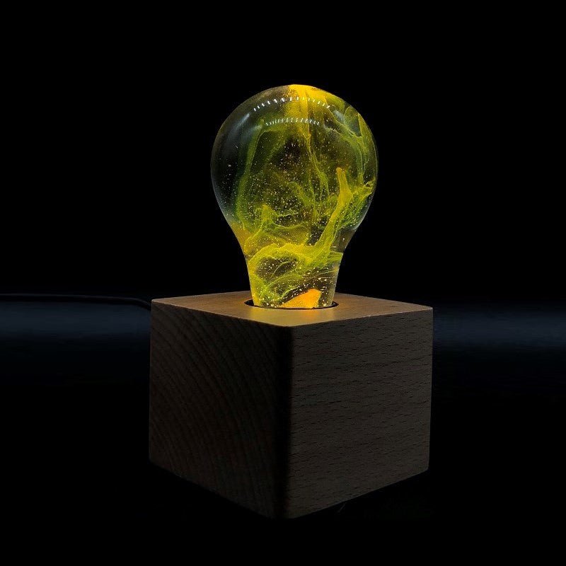 EP Light - Galaxy bulb glowing with yellow galactic swirls on a wooden cube base, eco-friendly and stylish LED light.