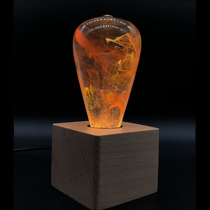 EP Light - Nebula handcrafted LED bulb with unique nebula design glowing warmly on wooden base.