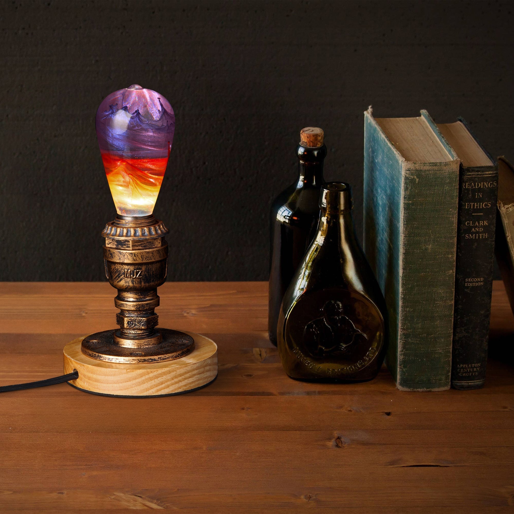 EP Light - Passion handcrafted bulb glowing warmly on vintage stand beside books and bottles on wooden surface.