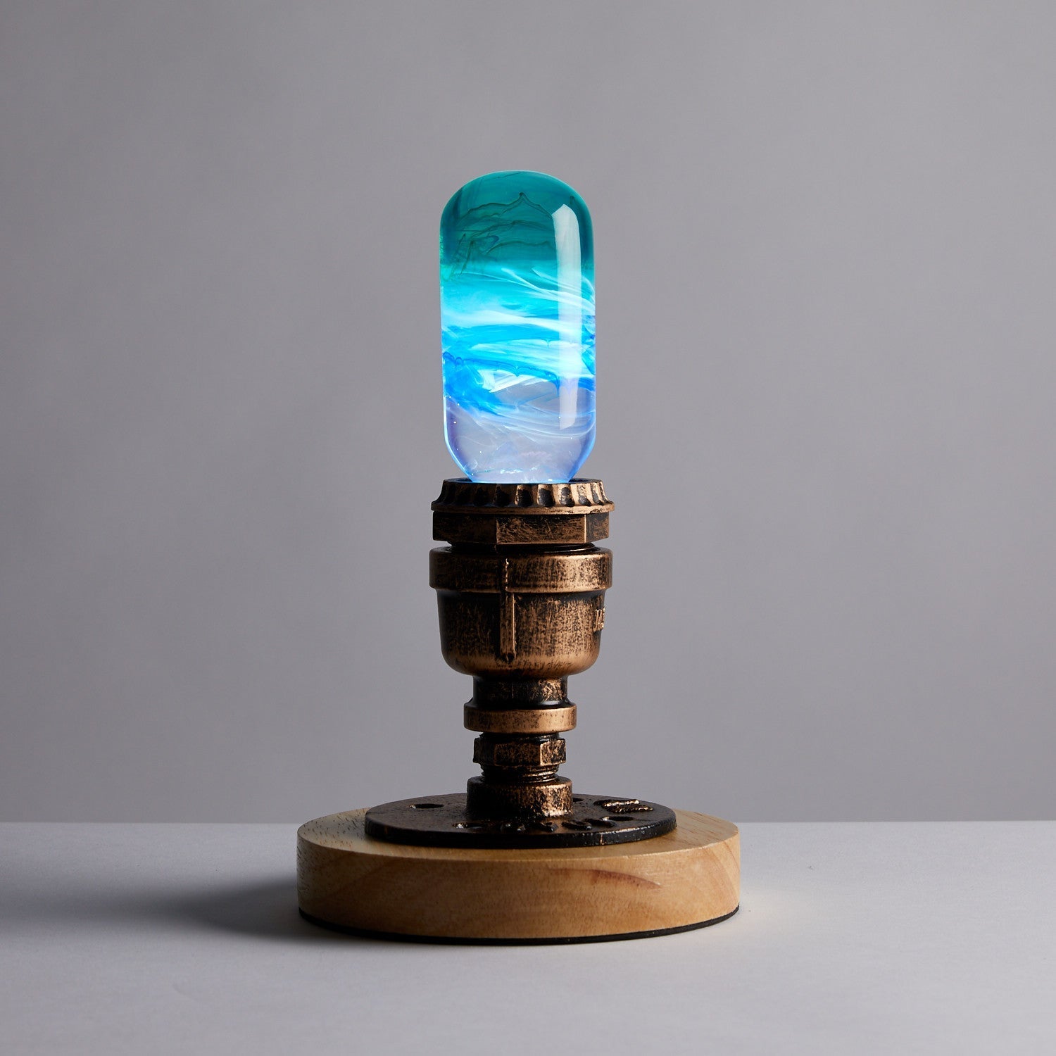 EP Light - Prairie bulb with unique handcrafted blue resin design on vintage brass base, energizing artistic home ambiance.