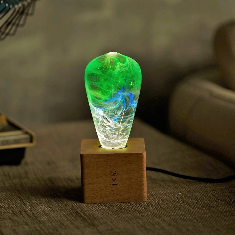 EP Light - Spring glowing handcrafted eco-resin bulb with unique green and blue patterns on wooden base.