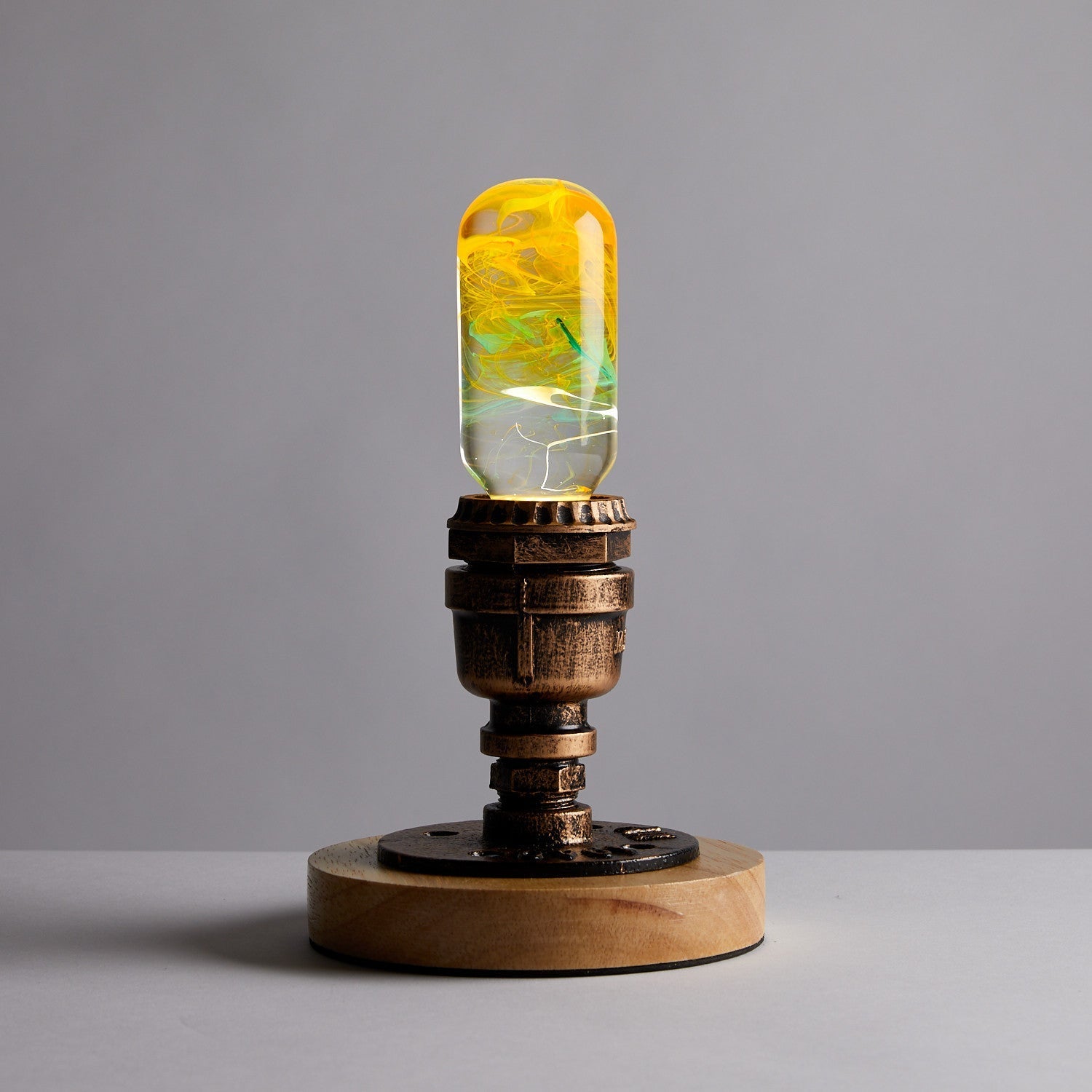 EP Light - Time handcrafted eco-resin bulb with unique yellow design on rustic wooden base, perfect for artistic lighting.