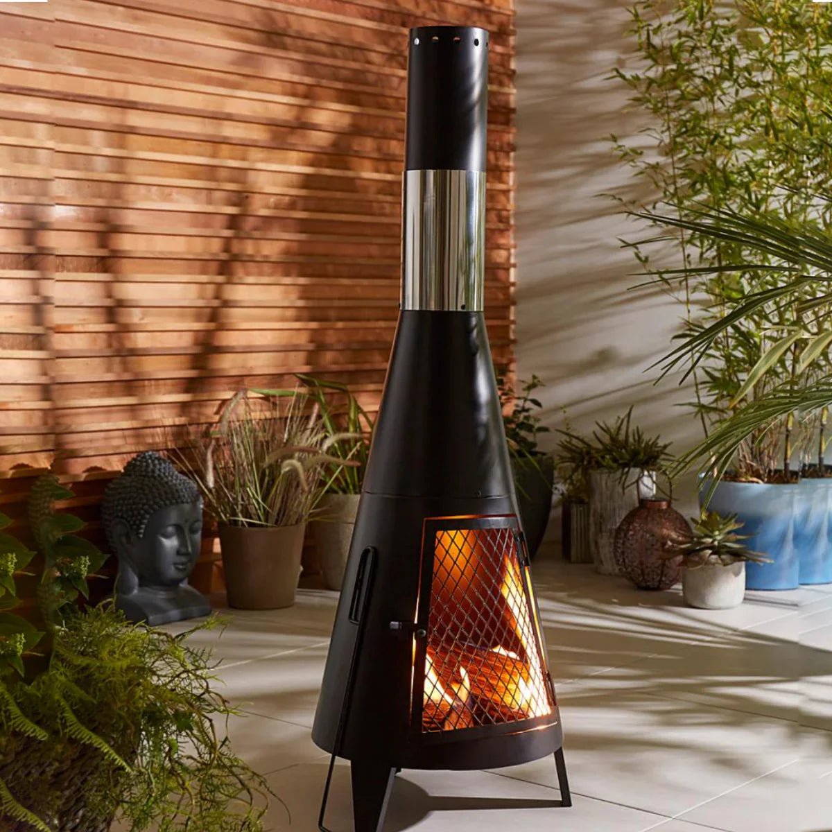 Modern Mesh Chiminea Fireplace burning wood in stylish garden setting for warm outdoor ambiance