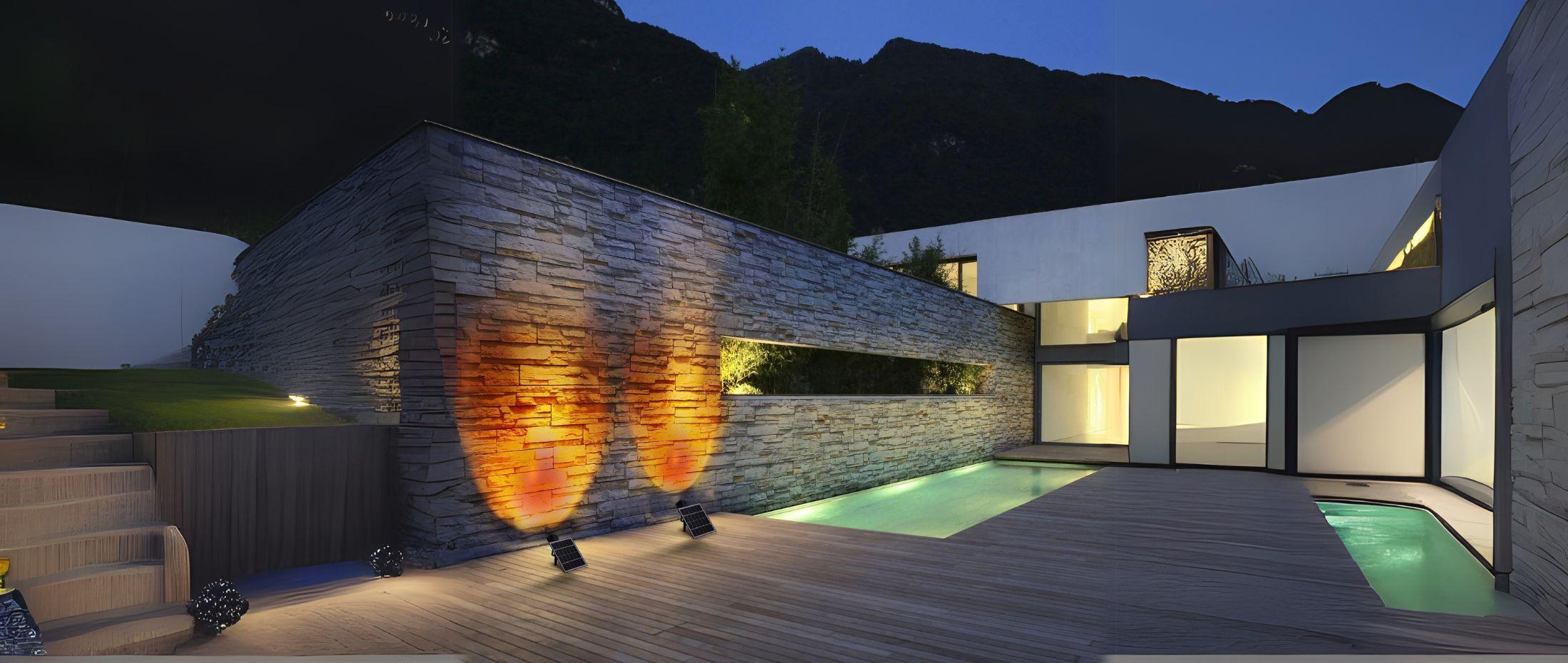 Modern courtyard with dramatic stone wall lighting, reflecting warm tones near a pool and sleek architectural design.