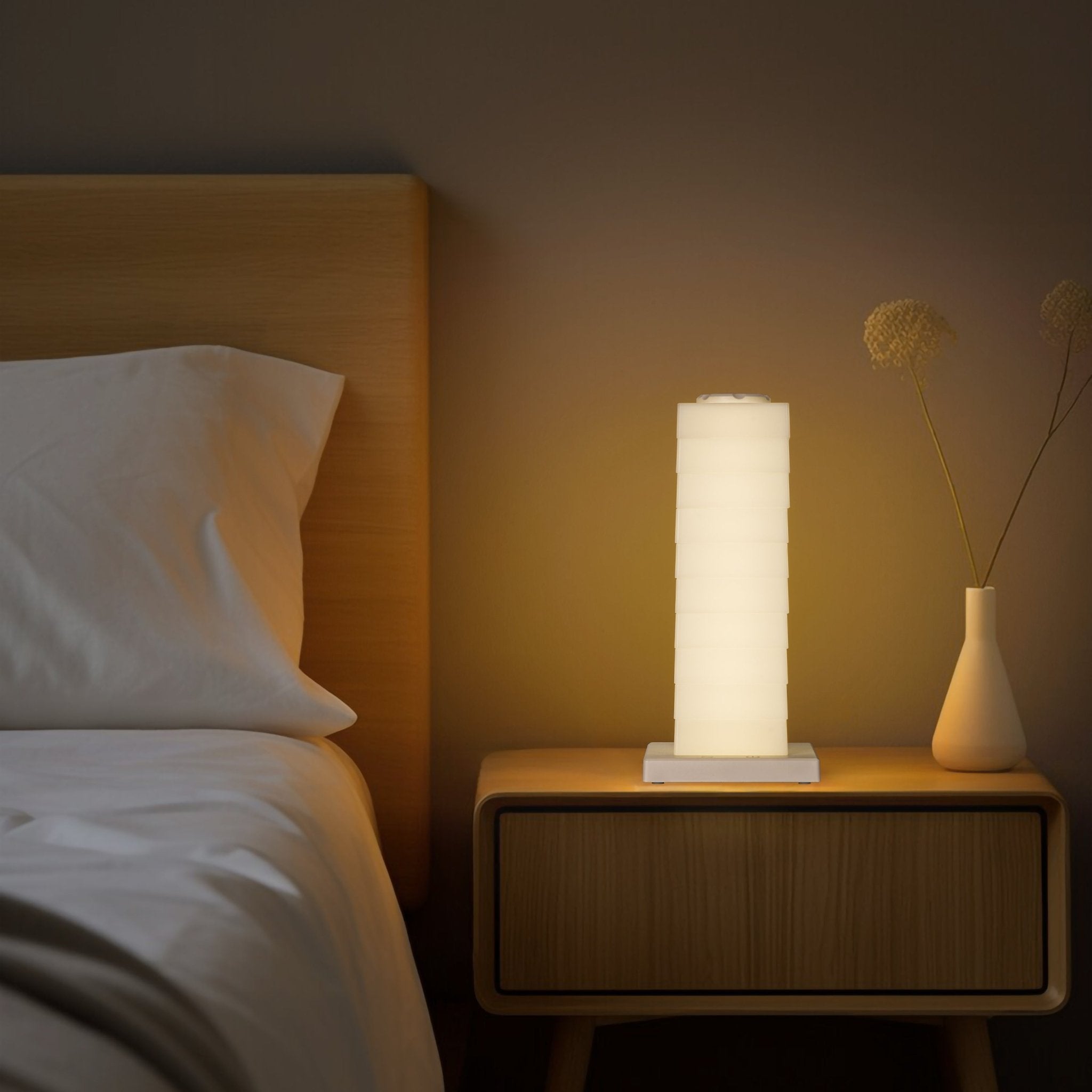 Modular Rotating Touch RGB Lamp glowing warmly on bedside table, enhancing modern bedroom ambiance with customizable light.