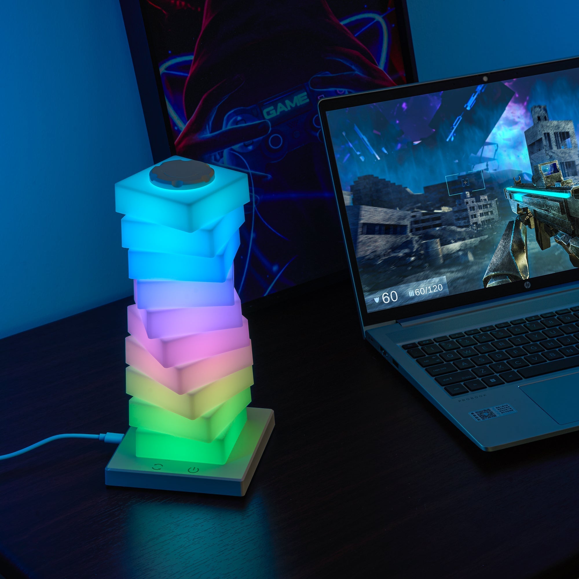 Modular Rotating Touch RGB Lamp glowing in RGB colors on a desk beside a gaming laptop for ambient lighting.