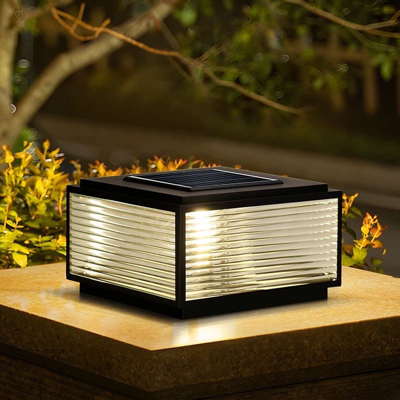 Outdoor Solar Powered Post Cap Lights glowing warmly on a garden pillar with sleek metal and glass design.