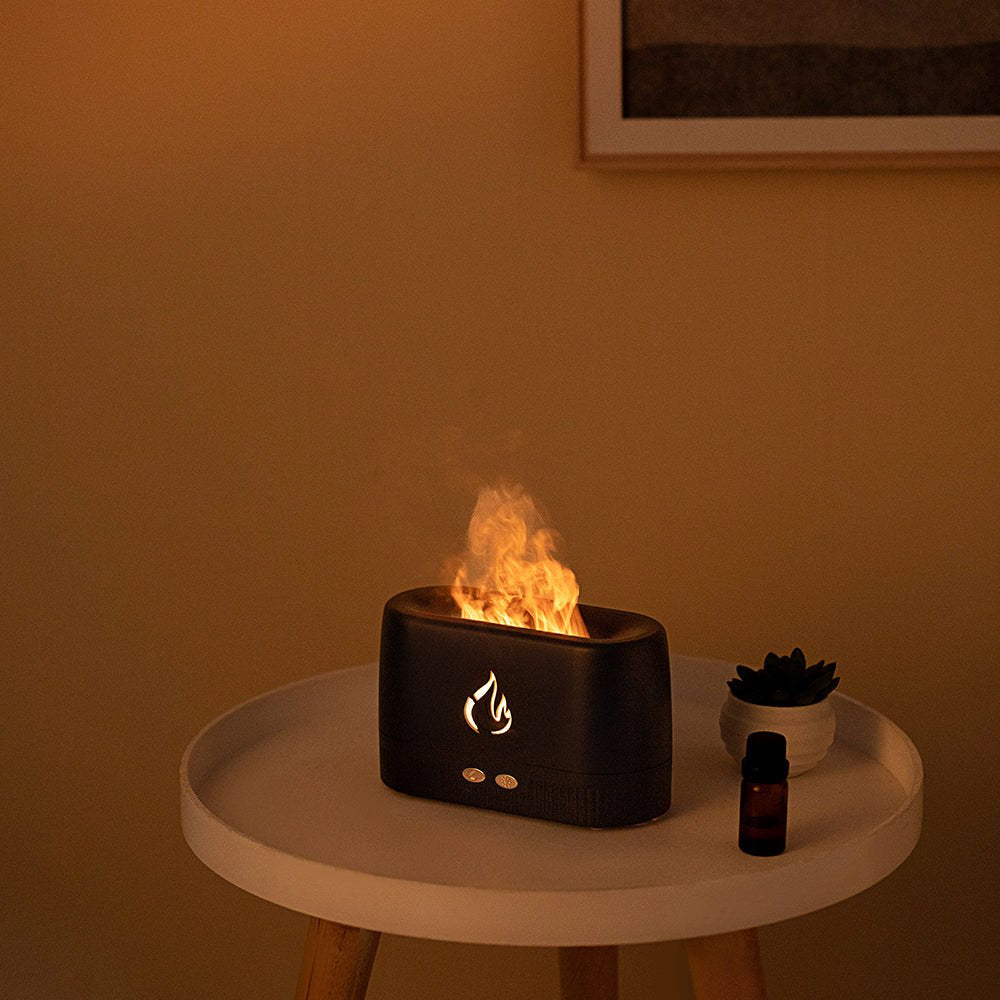 Portable Flame Diffuser & Humidifier on a table emitting soothing mist and warm LED flame glow for relaxation.