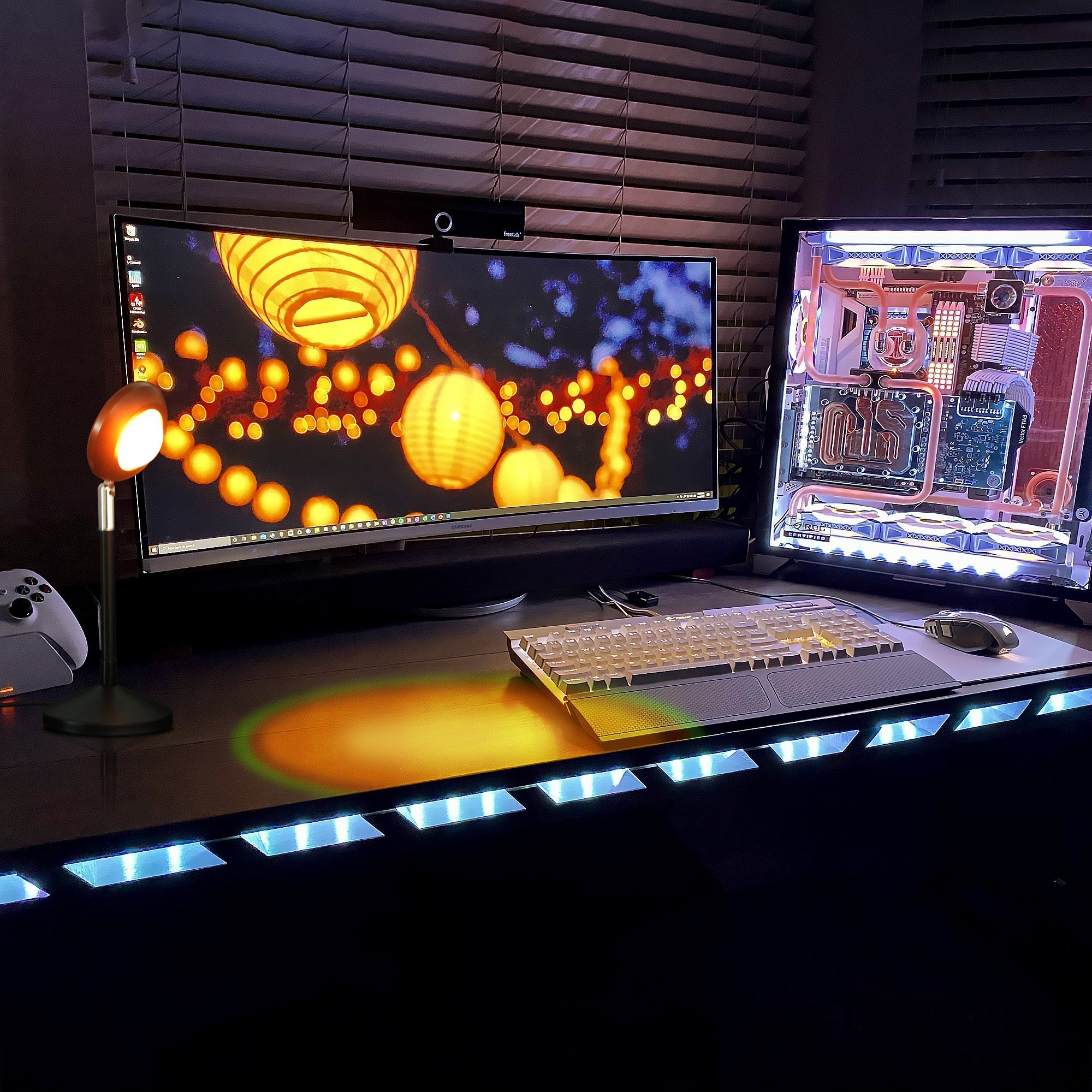 RGB Sunset Projector Lamp casting warm, vibrant sunset light on a sleek modern desk setup with gaming PC and monitor.