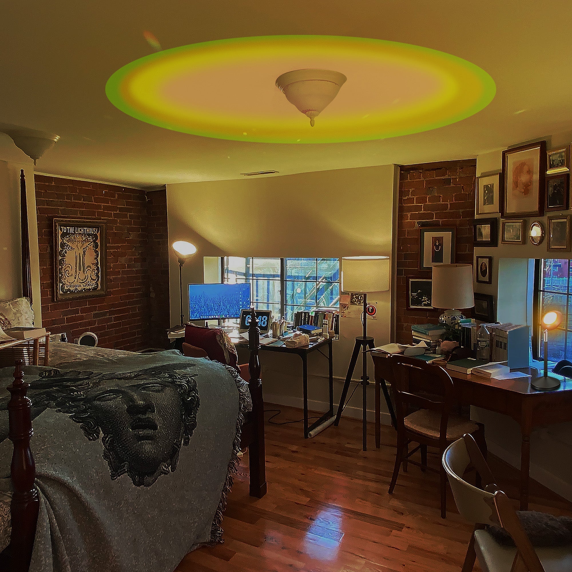 RGB Sunset Projector Lamp casting warm colorful light on ceiling in cozy modern bedroom ambiance.
