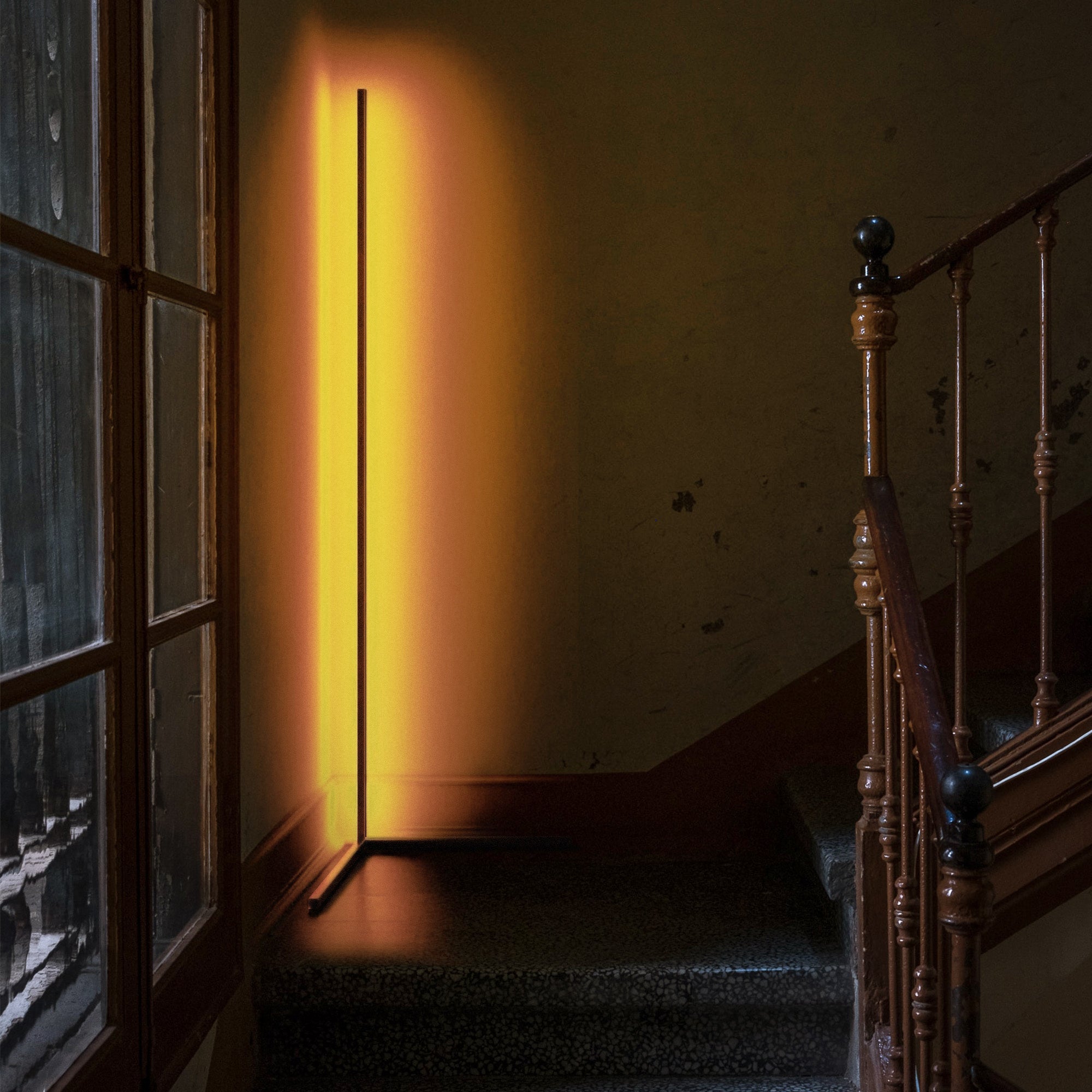 RGBCW Corner Floor Lamp illuminating a narrow stairwell corner with warm, minimalist LED lighting for stylish mood enhancement.