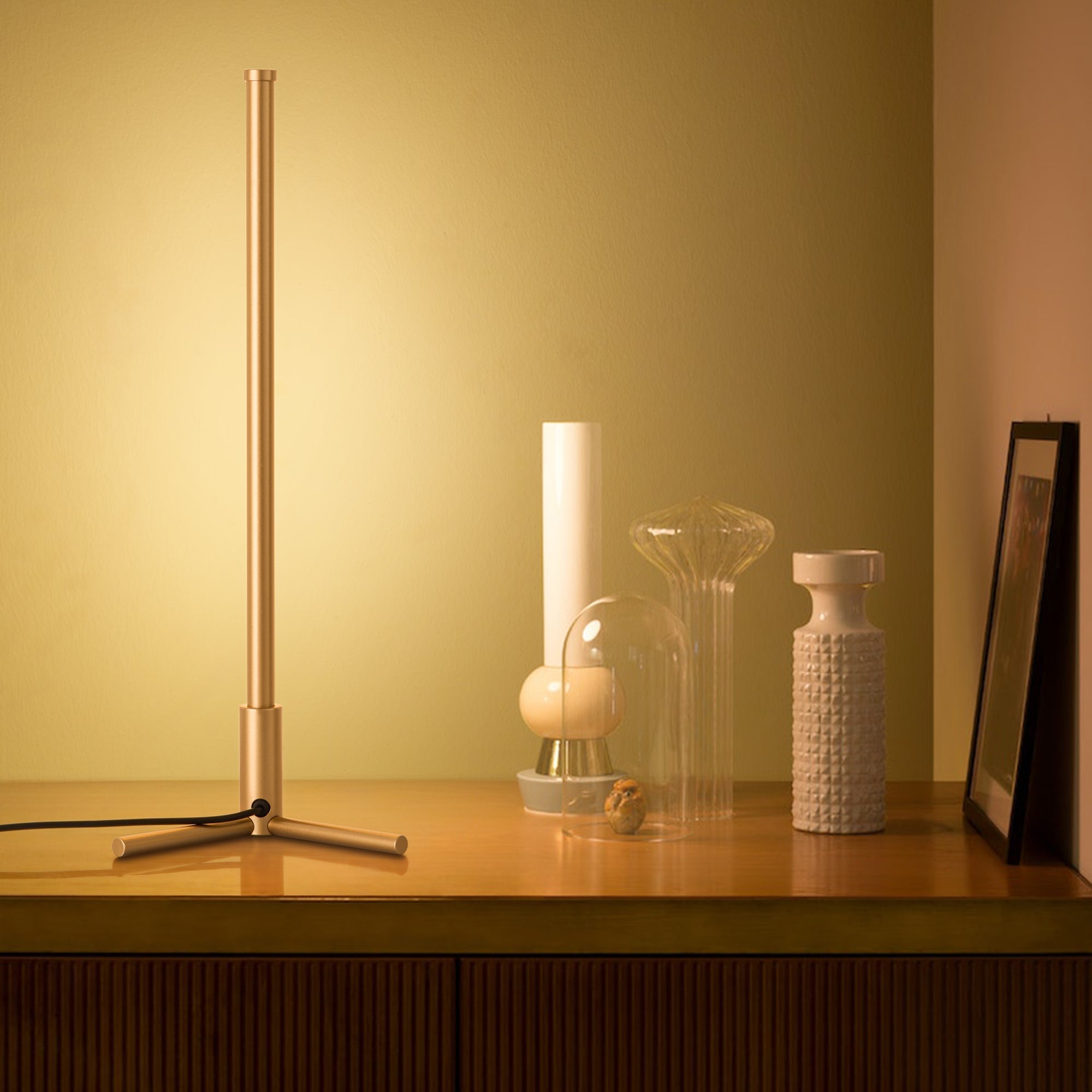 RGBCW Corner Table Lamp - Gold with minimalist vertical frame illuminating a stylish wooden surface and decor.