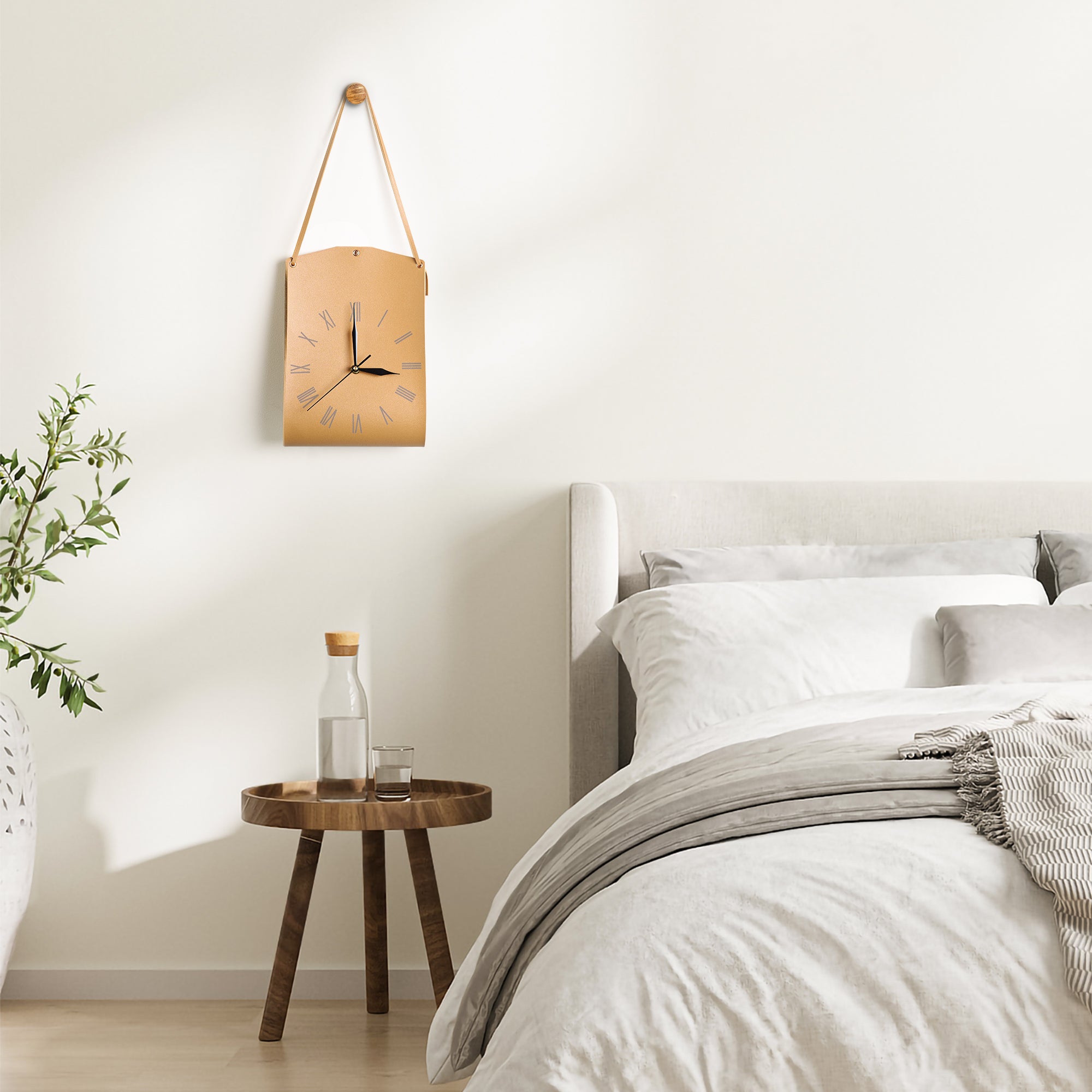 Roman Numerals Leather Wall Clock hanging on wall above wooden side table in minimalist bedroom decor