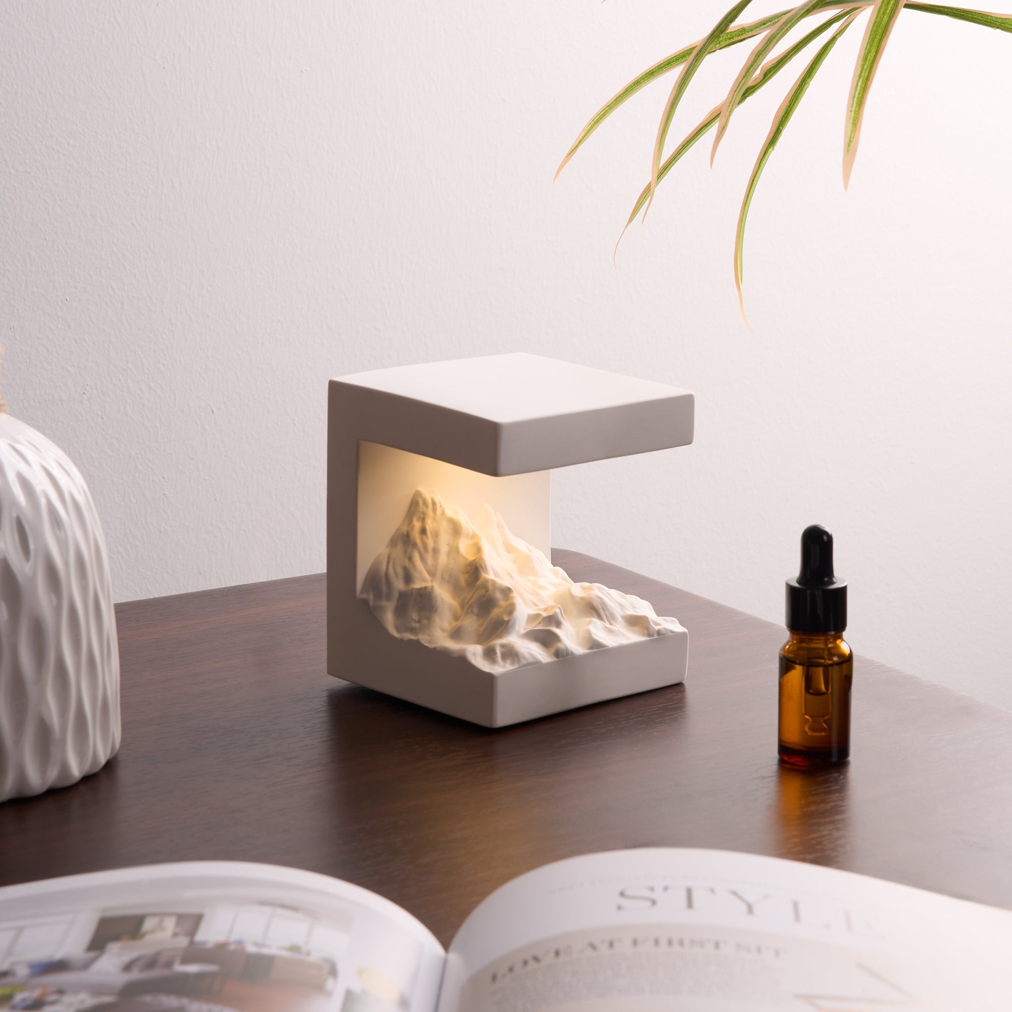 Snow Mountain Night Light & Diffuser Stone with adjustable warm light and oil diffuser for calming ambiance on desk.