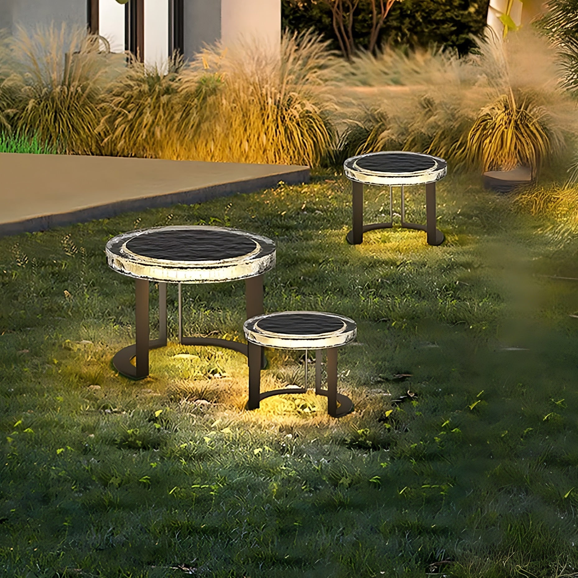 Solar Glow LED Garden Table trio glowing warmly at night powered by solar energy for stylish outdoor ambiance.