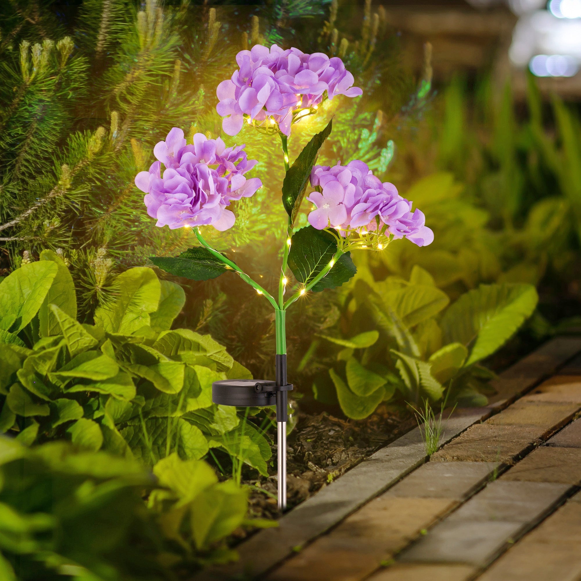 Solar Powered Hydrangea Pathway Light illuminating garden with eco-friendly, wire-free, glowing purple flower design along walkway.