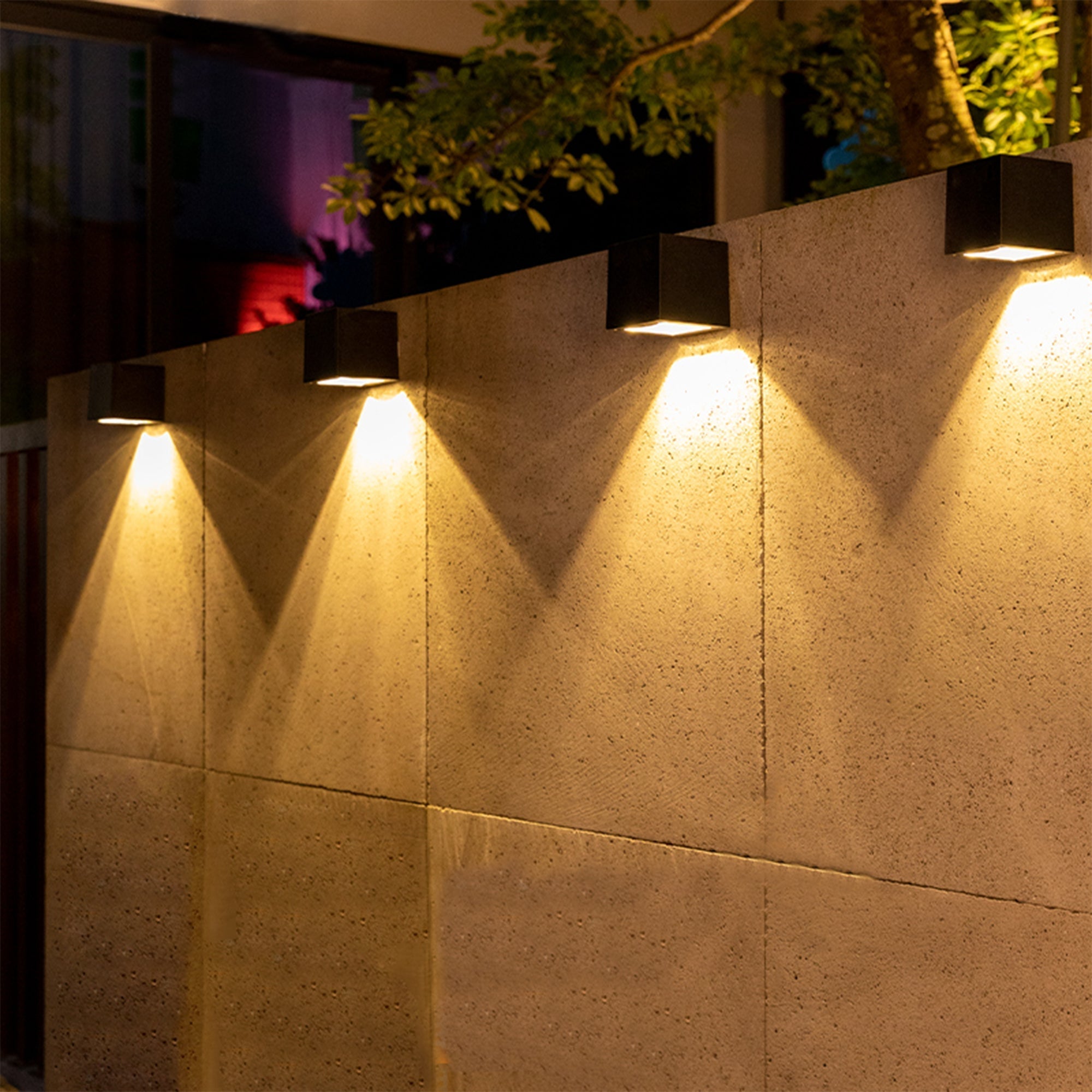 Solar Powered Outdoor Landscape Wall Lights illuminating a garden wall with warm, adjustable lighting at night.
