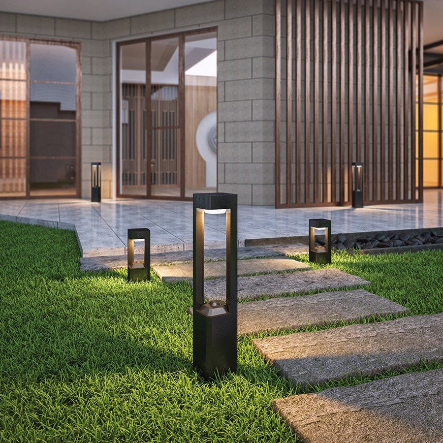 Solar Powered Outdoor Landscaping Path Lights illuminating garden walkway with modern black aluminum fixtures.