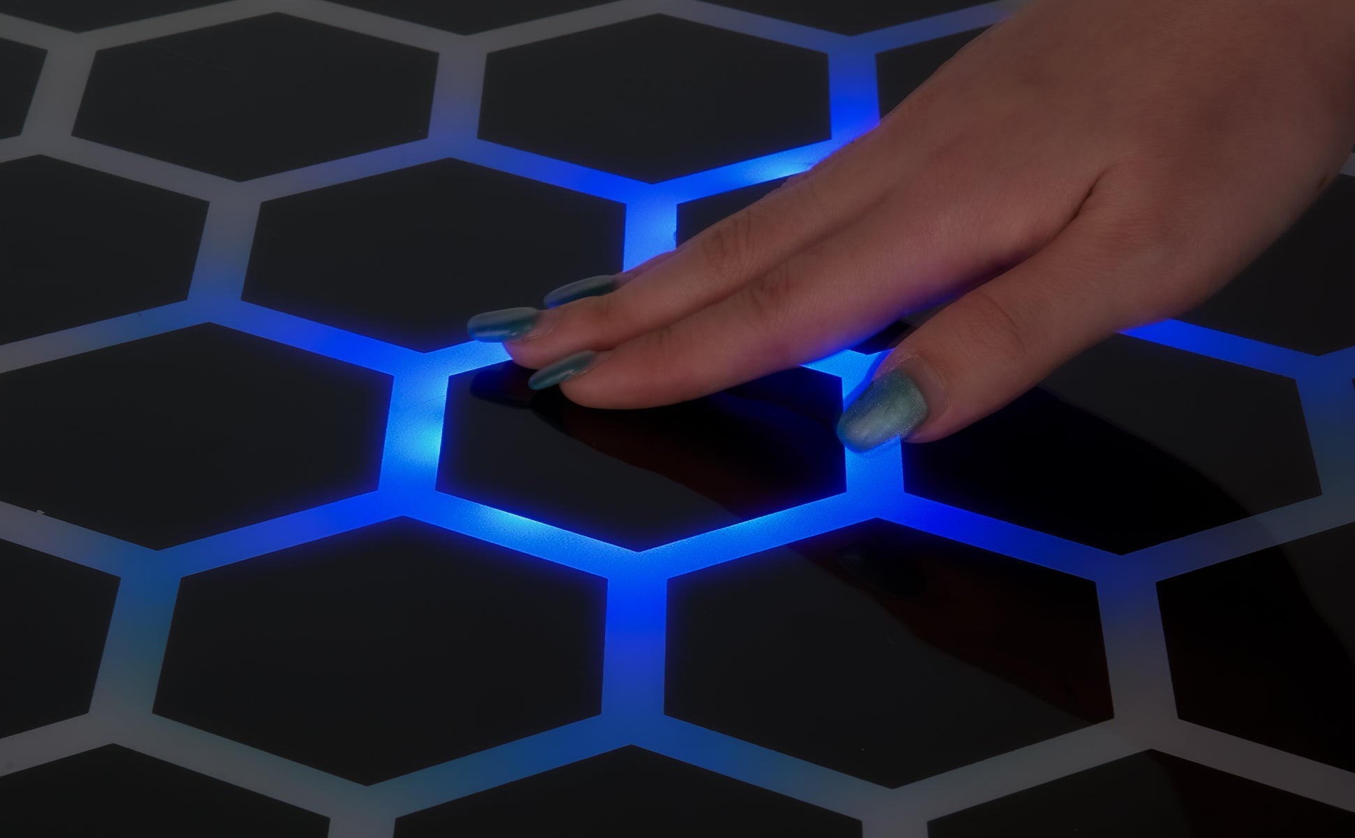 Touch & Glow Coffee Table illuminated blue hexagonal surface glowing with touch interaction on sleek modern design.