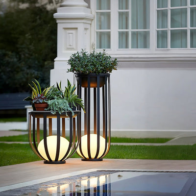 Outdoor Solar Power LED Plant Stand with glowing solar lights illuminating elegant potted plants outdoors.